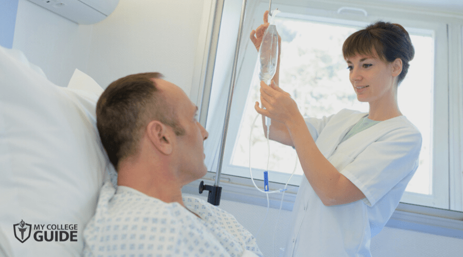 Nurse replacing IV fluids for patient