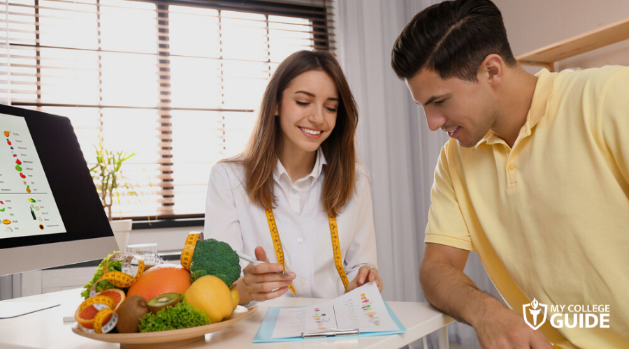 Nutritionist showing diet plan to her client