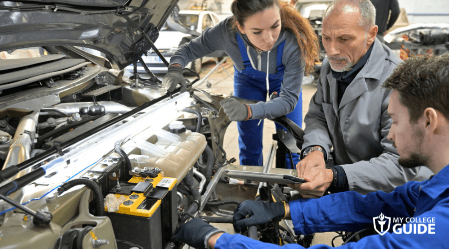 Teacher and students in an automotive mechanic trade school