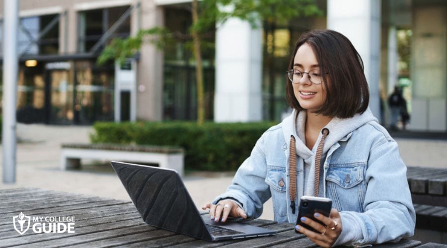 Student taking online college studying outdoor
