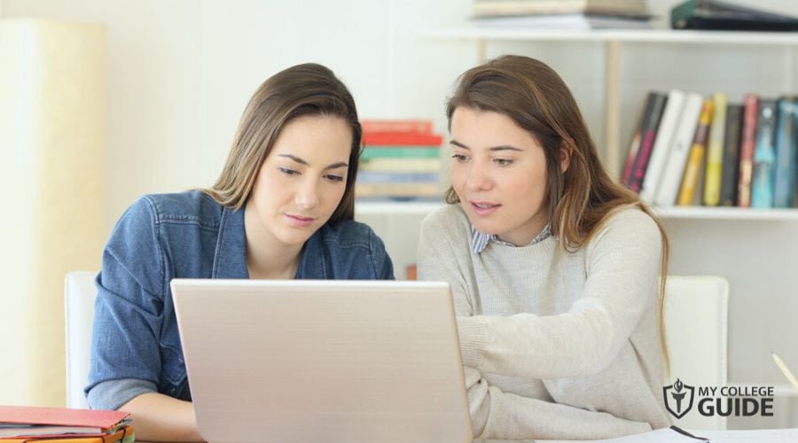 Friends checking on Economics Degree Programs online
